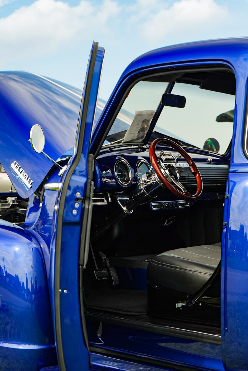 Conrad Captures photograph: royal-blue classic Chevrolet truck with the door open, wood steering wheel, and chrome Chevrolet badge.