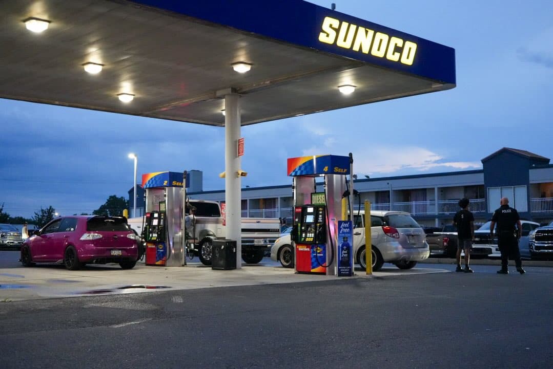 Pink hatchback at a Sunoco station at dusk