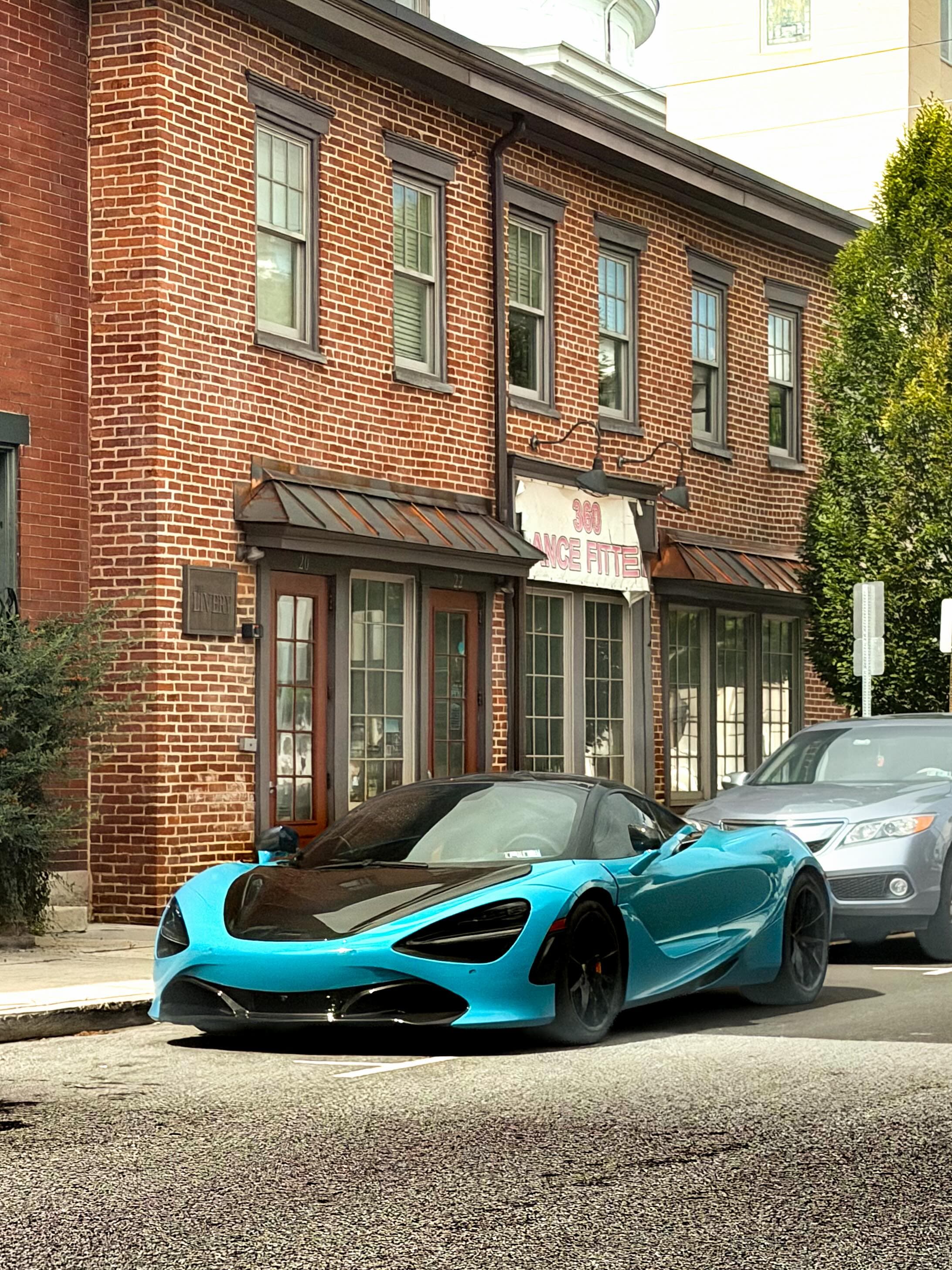 Cyan McLaren 720S on a brick-street block